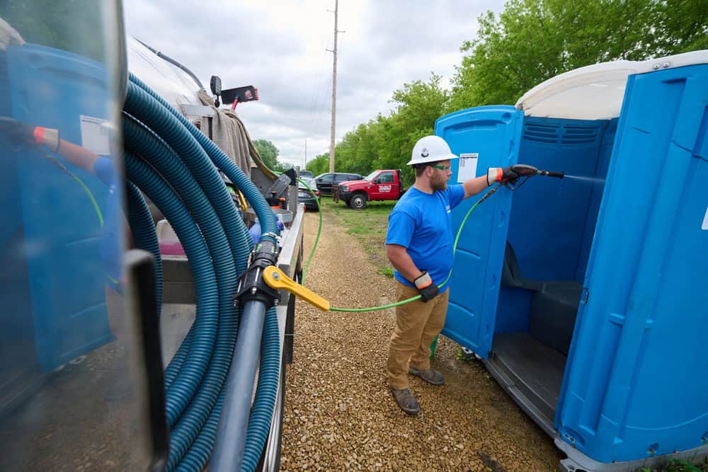 man cleaning units with a specialized hose