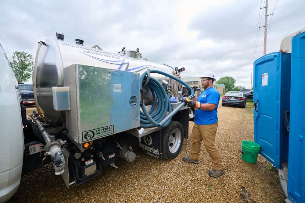 man organizing hoses onto truck